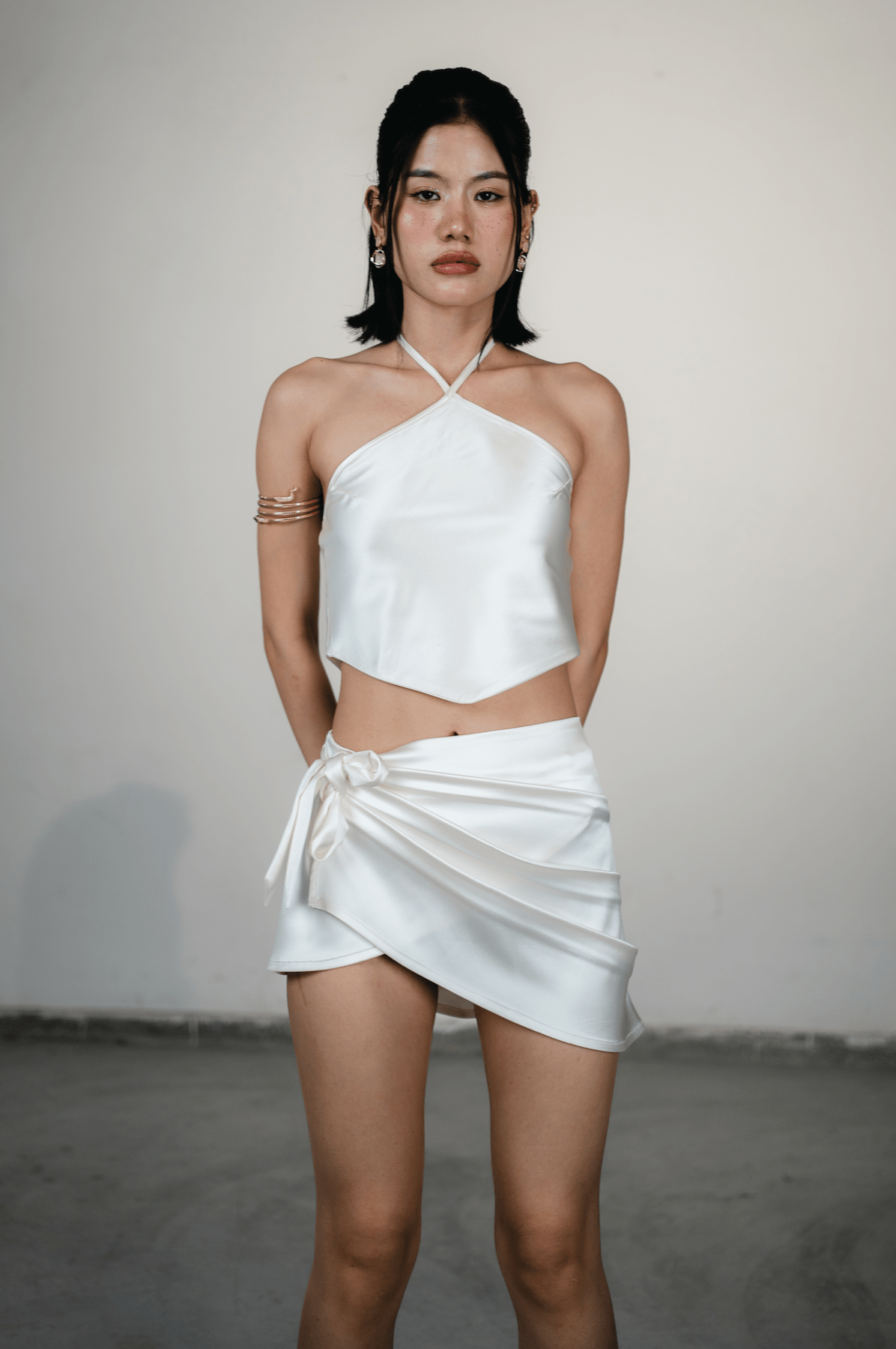 women wearing white satin cowl wrap mini skirt with draped front detail