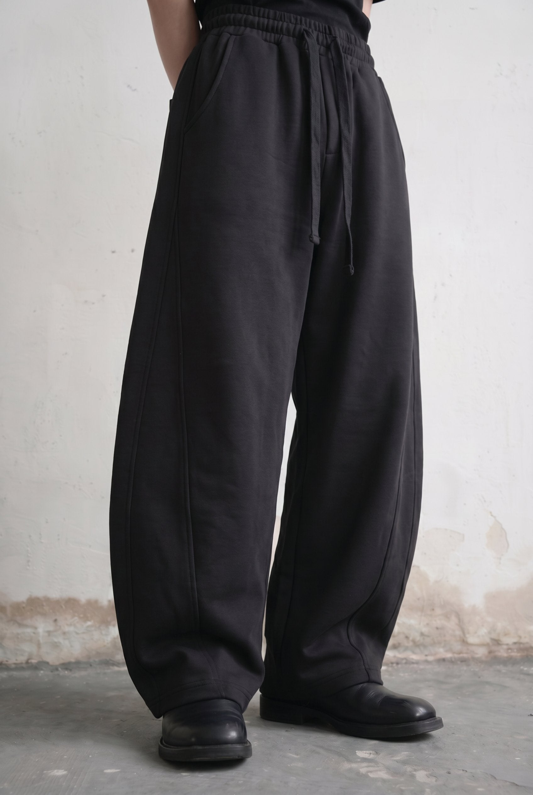 Black Eyelet Barrel Sweatpants — angled view of curved seams