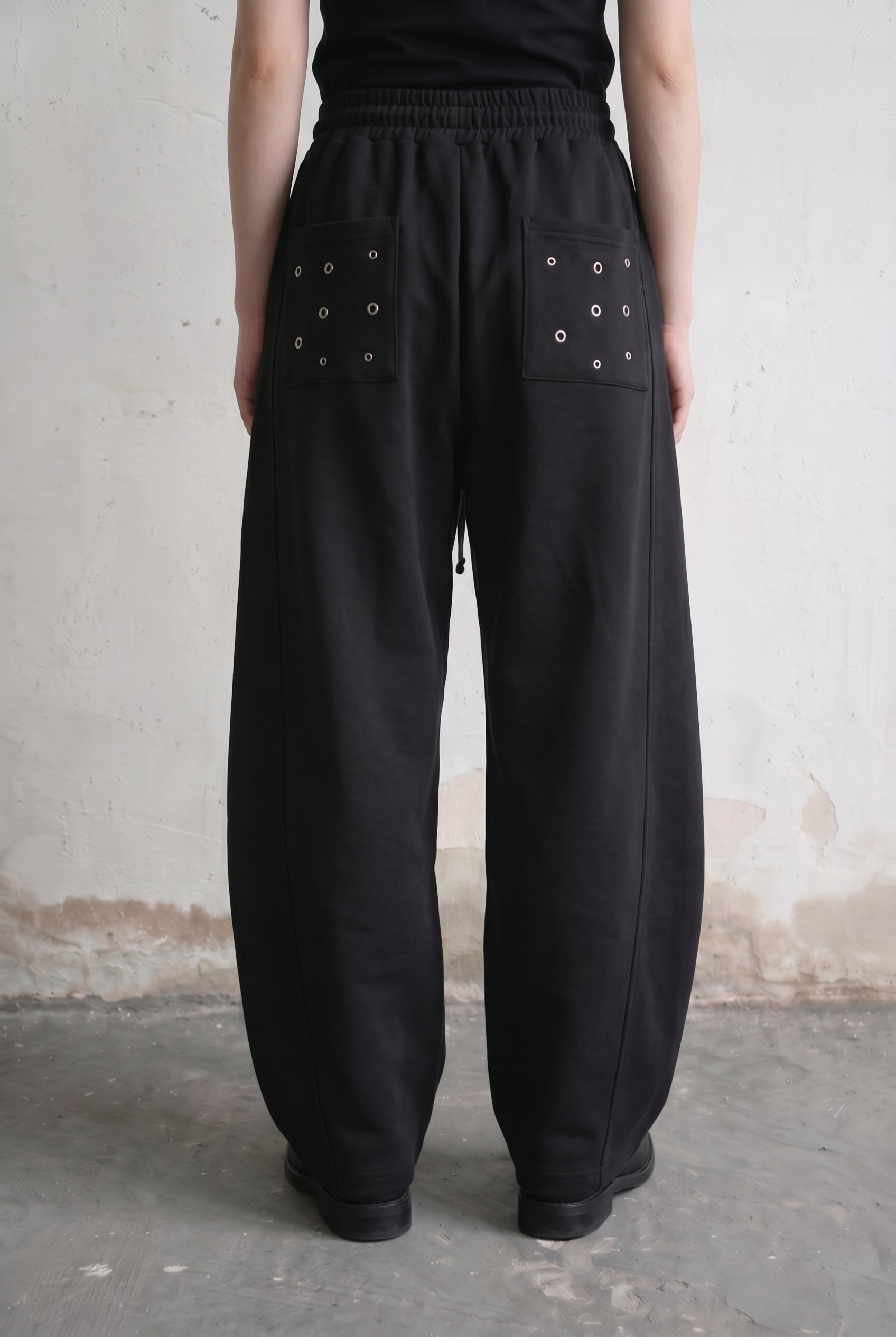 Black Eyelet Barrel Sweatpants — back view with eyelet-detail patch pockets