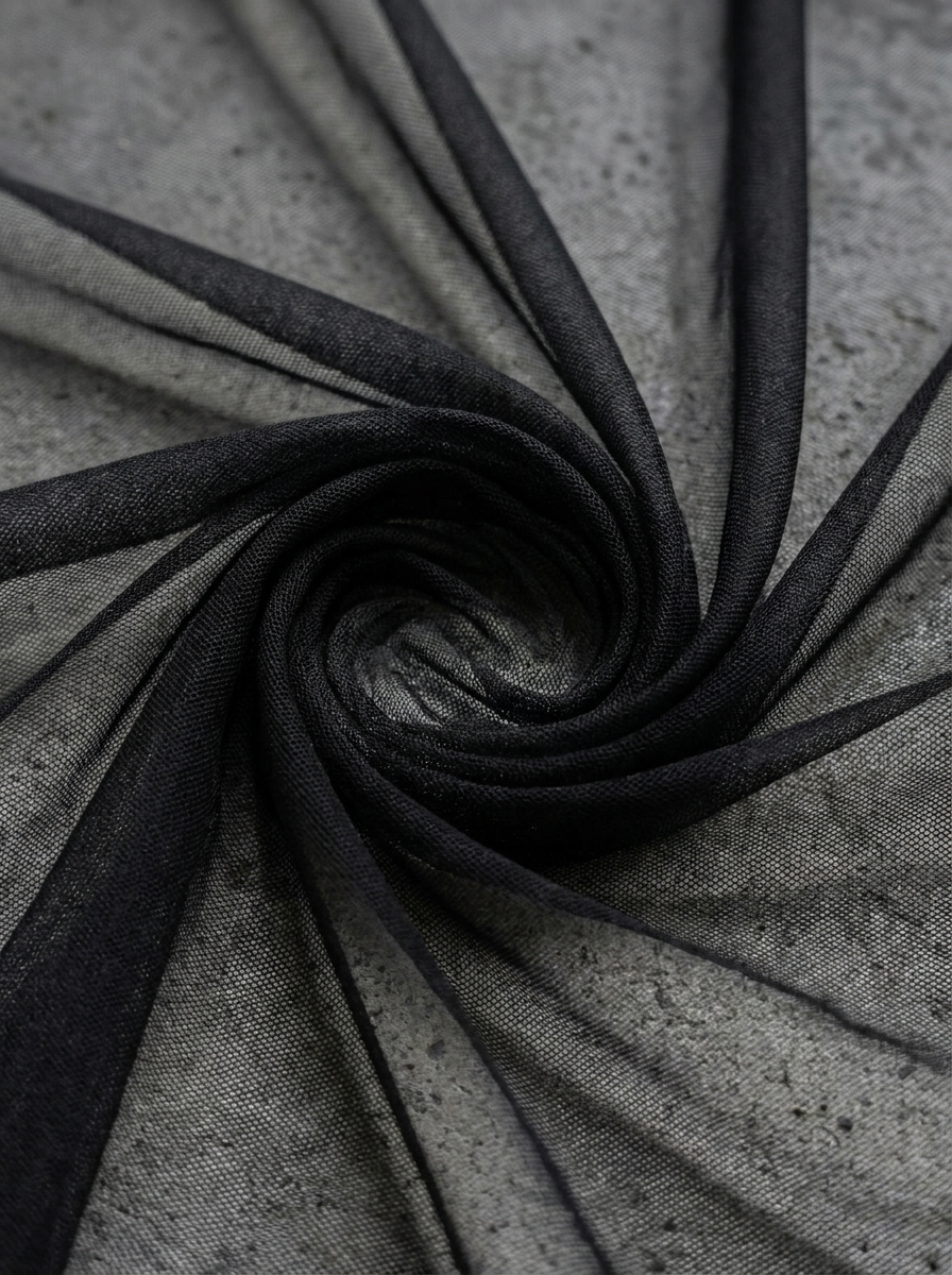 Close-up of power mesh fabric in a soft fold on grey cement