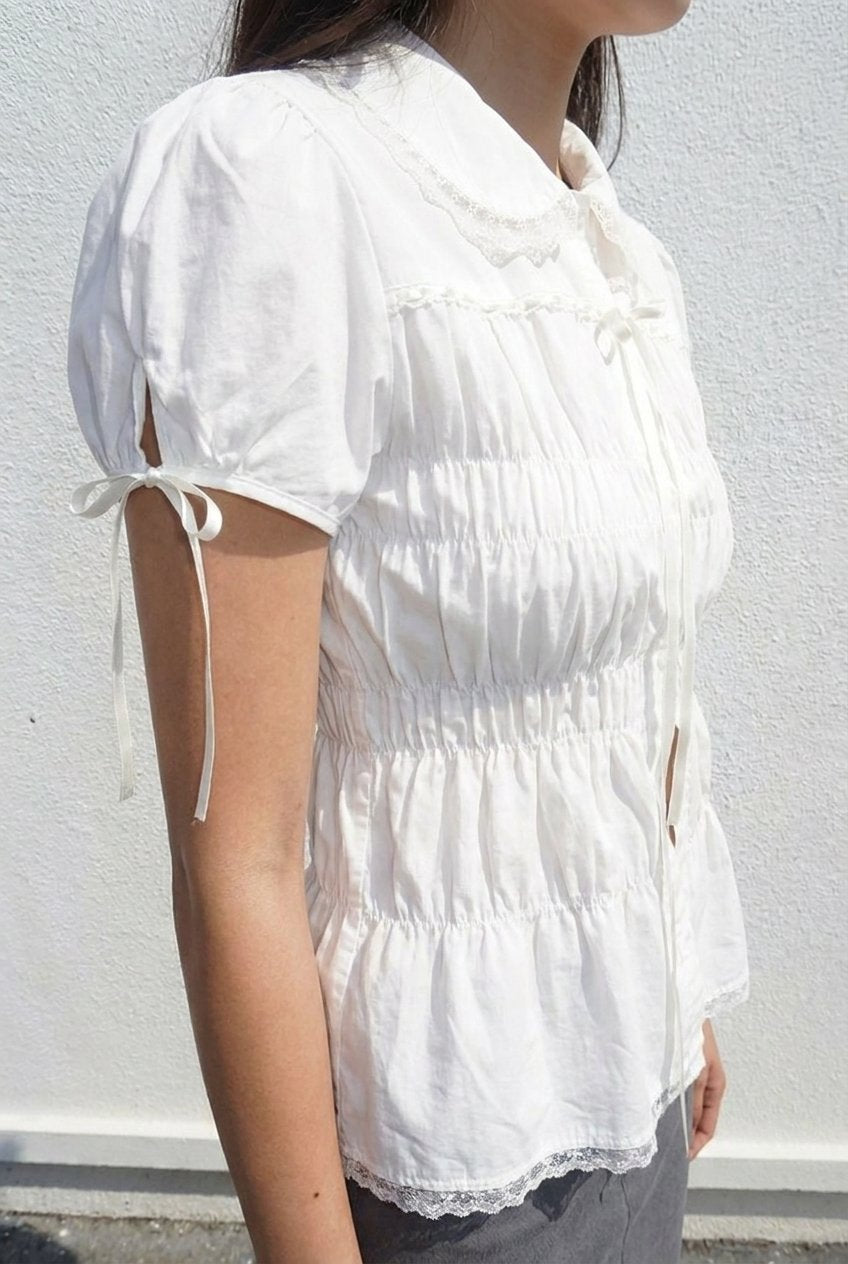 White Shirred Lace Blouse - side view with tie-cuff puff sleeves